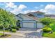 Two-story home with a three-car garage, well manicured lawn and stone accents at 4093 Epic Cv, Land O Lakes, FL 34638