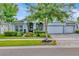 Charming home exterior with a three-car garage, well-manicured landscaping, and a covered front porch at 4093 Epic Cv, Land O Lakes, FL 34638