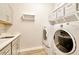 A laundry room featuring a sink and white appliances at 4093 Epic Cv, Land O Lakes, FL 34638