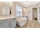 Relaxing main bathroom featuring double sinks, a soaking tub, and a walk-in shower at 4093 Epic Cv, Land O Lakes, FL 34638