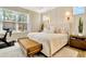 Sun-filled main bedroom featuring a large bed, bench and bright windows at 4093 Epic Cv, Land O Lakes, FL 34638
