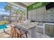 Screened in outdoor kitchen with a bar and grill at 4093 Epic Cv, Land O Lakes, FL 34638