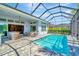 Sparkling pool inside screened lanai with outdoor kitchen, bar, and seating area, ideal for relaxation at 4093 Epic Cv, Land O Lakes, FL 34638