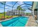 Backyard featuring a screened in pool and spa at 4093 Epic Cv, Land O Lakes, FL 34638