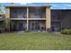 Exterior view of building with screen patios and green space at 413 Somerset Ln, Palm Harbor, FL 34684