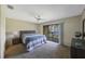 Bright bedroom with a sliding door to a private balcony, a ceiling fan, and neutral decor at 413 Somerset Ln, Palm Harbor, FL 34684