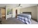 Bright bedroom with a sliding door to a private balcony, vanity area, and neutral decor for relaxation at 413 Somerset Ln, Palm Harbor, FL 34684
