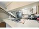 Bright kitchen featuring white cabinets, stainless steel appliances, and a view of the stairs at 413 Somerset Ln, Palm Harbor, FL 34684