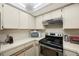 Cozy kitchen features modern appliances and ample cabinet space, enhancing functionality at 413 Somerset Ln, Palm Harbor, FL 34684