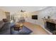 Open-concept living room featuring modern kitchen, breakfast bar, stone fireplace, and comfortable seating at 413 Somerset Ln, Palm Harbor, FL 34684