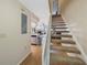 Carpeted stairs with white railing leading to the upper level, adjacent to the kitchen and living area at 413 Somerset Ln, Palm Harbor, FL 34684