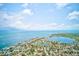 An aerial view showcasing a coastal community with canal homes, open water, and stunning blue skies at 4228 Tarpon Se Dr, St Petersburg, FL 33705