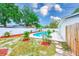 Beautiful backyard with a pool, lush landscaping, a white fence, and a patio area at 4228 Tarpon Se Dr, St Petersburg, FL 33705