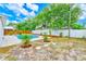 Backyard featuring a swimming pool with stepping stones, white fence, and tropical landscaping at 4228 Tarpon Se Dr, St Petersburg, FL 33705