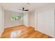 Spacious bedroom with wood flooring, a ceiling fan, a large window, and a double door closet at 4228 Tarpon Se Dr, St Petersburg, FL 33705