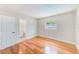 Bedroom showing bathroom doorway, hardwood floors, neutral walls, and a window at 4228 Tarpon Se Dr, St Petersburg, FL 33705