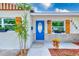 Close-up of a charming home's entrance, featuring a vibrant blue front door and decorative shutters at 4228 Tarpon Se Dr, St Petersburg, FL 33705