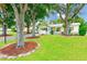 Charming home featuring a lush green lawn adorned with mature trees and mulch beds at 4228 Tarpon Se Dr, St Petersburg, FL 33705