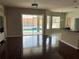 Open-concept living space with hardwood flooring, sliding glass doors to pool, and breakfast bar to kitchen at 4512 River Overlook Dr, Valrico, FL 33596