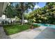A lush backyard features mature trees and landscaping around a sparkling swimming pool at 4705 W Estrella St, Tampa, FL 33629