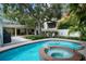 The spacious backyard features a large in-ground pool, spa, mature trees, and an outdoor dining area at 4705 W Estrella St, Tampa, FL 33629