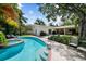 A lovely backyard features a pristine pool with a spa, luscious landscaping, and an outdoor dining area at 4705 W Estrella St, Tampa, FL 33629