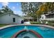 A beautiful backyard features a pristine pool with spa, a large shade tree, and outdoor seating area at 4705 W Estrella St, Tampa, FL 33629