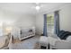 Bright bedroom with a white crib, chair, and ottoman, complemented by stylish decor and natural light at 4705 W Estrella St, Tampa, FL 33629