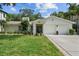 Charming single-story home with a lush front lawn, blooming flowers, and a two car garage at 4705 W Estrella St, Tampa, FL 33629