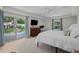 Bedroom with a white bed, sliding glass door, and an adjacent workspace at 4705 W Estrella St, Tampa, FL 33629