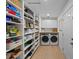 Walk-in pantry and laundry area with floor-to-ceiling shelves and a side-by-side washer and dryer at 4705 W Estrella St, Tampa, FL 33629