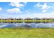 Scenic view of backyards lining a pond, reflecting the blue sky with fluffy clouds at 4914 Sienna Isles Ave, Wimauma, FL 33598