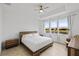 Light-filled bedroom with a tray ceiling, neutral walls, and large windows offering a tranquil water view at 4914 Sienna Isles Ave, Wimauma, FL 33598