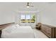 Bright primary bedroom featuring a tray ceiling, light walls, and multiple windows with peaceful water views at 4914 Sienna Isles Ave, Wimauma, FL 33598