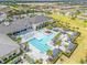 Aerial view of the community pool with cabanas, lounge chairs, and dining with lush surrounding landscapes at 4914 Sienna Isles Ave, Wimauma, FL 33598