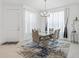 Contemporary dining room with modern chandelier, sleek table and seating, and natural light at 4914 Sienna Isles Ave, Wimauma, FL 33598