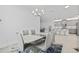 Elegant dining room with a modern chandelier, contemporary furniture, and an open view of the kitchen at 4914 Sienna Isles Ave, Wimauma, FL 33598