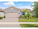 Charming single-story home with a paver driveway, mature landscaping, and a beige two-car garage door at 4914 Sienna Isles Ave, Wimauma, FL 33598