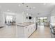 Open-concept kitchen with island, stainless steel appliances, and a seamless transition to dining and living areas at 4914 Sienna Isles Ave, Wimauma, FL 33598