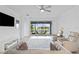 Bright living room with neutral decor, tile flooring, and a view of the screened-in patio overlooking the water at 4914 Sienna Isles Ave, Wimauma, FL 33598