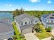 Aerial view of a gorgeous home featuring lush landscaping, a lake view, and solar panels on the adjacent home at 5040 Inshore Landing Dr, Apollo Beach, FL 33572
