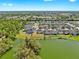 A panoramic aerial view showcasing a peaceful community with beautiful homes and a serene lake. Lots of trees and green spaces at 5040 Inshore Landing Dr, Apollo Beach, FL 33572