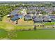 Aerial view of the community featuring many homes with backyard pools, a beautiful lake, and mature trees at 5040 Inshore Landing Dr, Apollo Beach, FL 33572