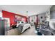 Comfortable bedroom with red accent wall, lots of plants, pendant lighting, and large picture frame at 5040 Inshore Landing Dr, Apollo Beach, FL 33572