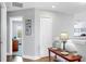 Bright hallway with hardwood floors, a decorative table, and views into an office space, enhancing the home's charm at 5040 Inshore Landing Dr, Apollo Beach, FL 33572