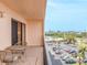Cozy balcony seating with views of the beach, cityscape, and palm trees from this beautiful condo at 51 Island Way # 503, Clearwater Beach, FL 33767