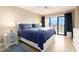 Bright bedroom featuring a large bed, balcony access, light wood floors, and neutral walls at 51 Island Way # 503, Clearwater Beach, FL 33767