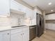 Bright kitchen featuring white cabinetry, stainless steel appliances, and tile backsplash at 51 Island Way # 503, Clearwater Beach, FL 33767