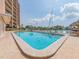 Community pool with comfortable lounge chairs surrounded by lush landscaping and sunny skies at 51 Island Way # 503, Clearwater Beach, FL 33767
