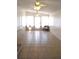 Light and airy living room with neutral tile flooring and ceiling fans at 5714 Cheyenne St, Zephyrhills, FL 33542
